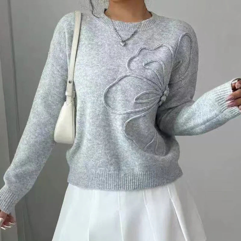 Elegancki i wygodny sweter z miękkiej wełny w jednolitym kolorze, z okrągłym dekoltem i minimalistycznym, a zarazem pięknym wzorem kwiatowym.