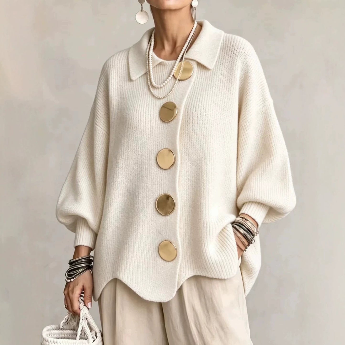 Ten sweter w stylu retro zdobią duże metalowe guziki, które nadają mu swobodny i luźny styl.