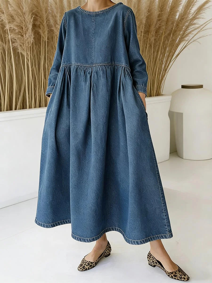 Elegancka i wygodna, luźna sukienka w kolorze jeansowym z okrągłym dekoltem i kieszeniami z przodu.
