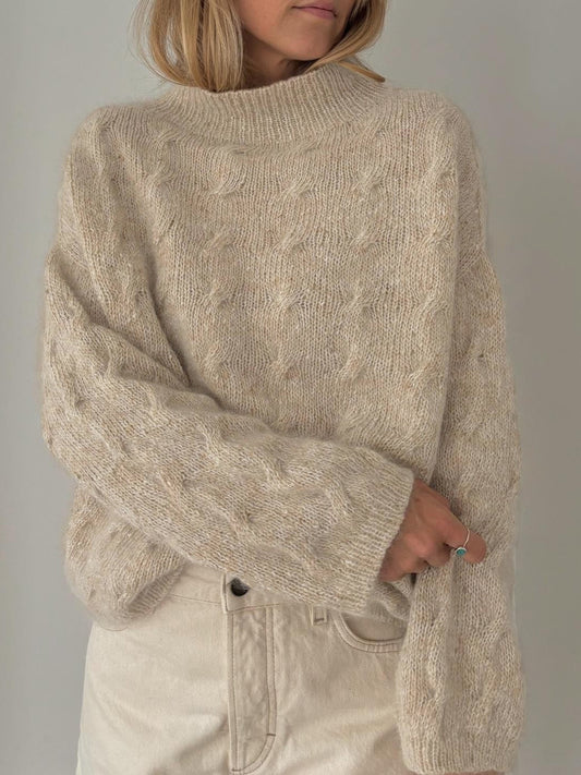 Elegancki i wygodny beżowy sweter wykonany ze splotu warkoczowego.