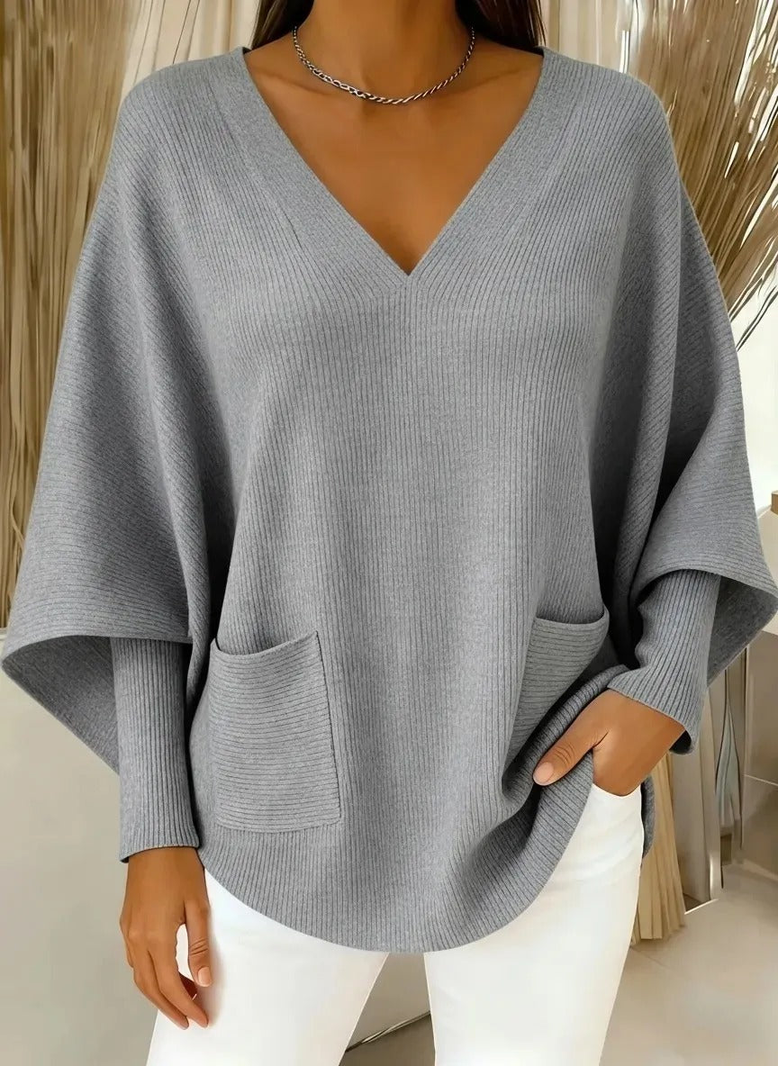 Ten stylowy sweter z dekoltem w serek ma luźny, swobodny krój i dopasowane mankiety, dzięki czemu wygląda świeżo i atrakcyjnie.