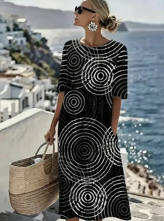 Wygodna czarna sukienka bez rękawów ozdobiona jest nieregularnym geometrycznym wzorem, który podkreśla jej wyrafinowany i elegancki styl.