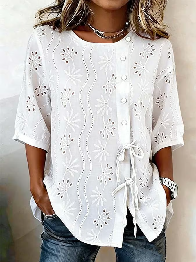 Ta jednokolorowa damska koszula wyróżnia się wyciętym wzorem kwiatowym, guzikami i krawatem, przez co jest uniwersalnym elementem garderoby.