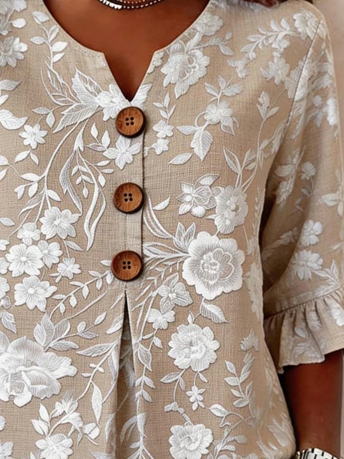 Elegancka i uniwersalna damska letnia koszula w kolorze khaki z dekoltem w serek, kwiatowym nadrukiem i falbankami przy mankietach.