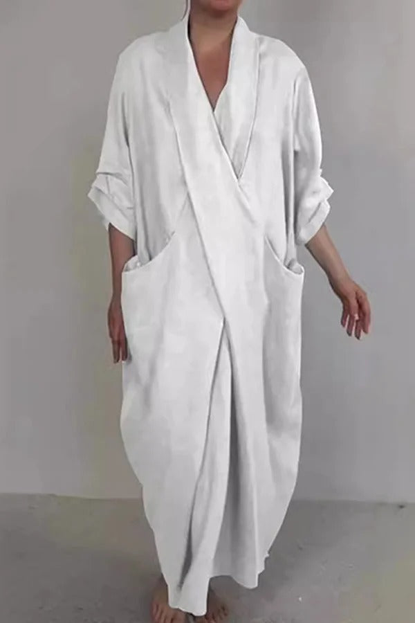 Luźna, elegancka i wygodna sukienka maxi w jednolitym kolorze, z rozcięciem w serek i kieszeniami.