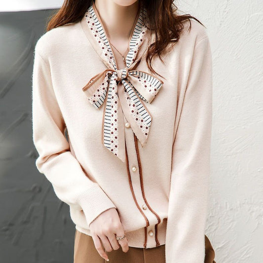 Klasyczny, jednokolorowy kardigan kaszmirowy w stylu retro, miękki w dotyku, z kokardą przy dekolcie.