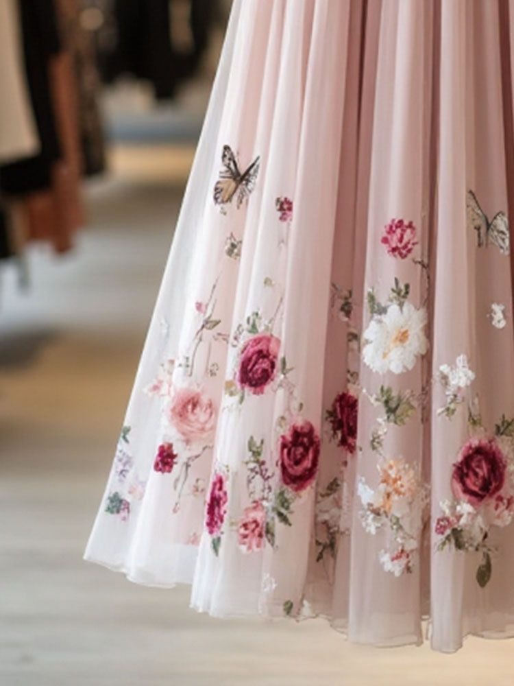 Ta wygodna, długa, różowa sukienka z tiulu, ozdobiona wykwintnymi haftowanymi wzorami kwiatowymi, emanuje świeżym i eleganckim urokiem.