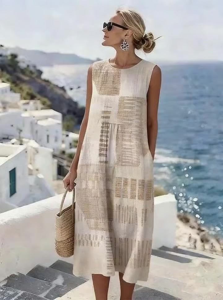 Elegancka i wygodna sukienka bez rękawów w kolorze khaki ozdobiona jest nieregularnym geometrycznym nadrukiem, który podkreśla jej wyrafinowany i elegancki styl.