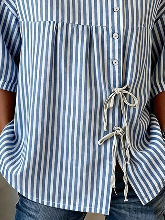 Ta niebieska koszula w drobne prążki, zapinana na guziki, jest wygodna, swobodna i uniwersalna.