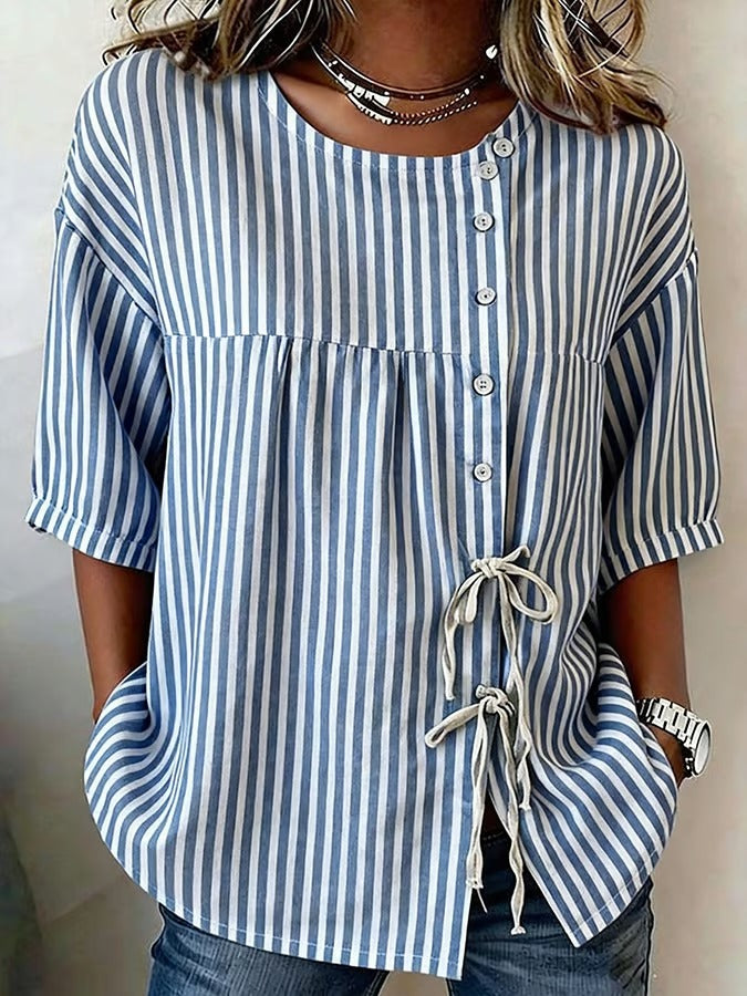 Ta niebieska koszula w drobne prążki, zapinana na guziki, jest wygodna, swobodna i uniwersalna.