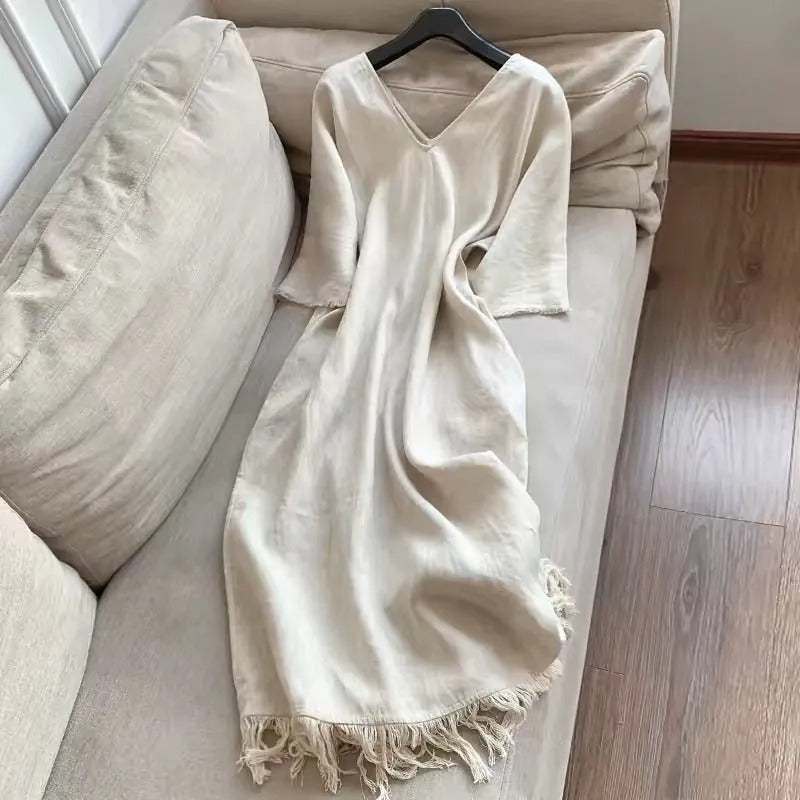 Elegancka, lniana sukienka w stylu francuskim, jednokolorowa, luźna, z dekoltem w serek i frędzlami u dołu.